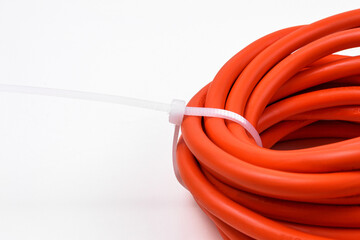 White cable ties on orange cable close up.