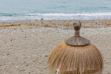 Fototapeta na wymiar A beach with natural fiber umbrellas to protect you from the sun