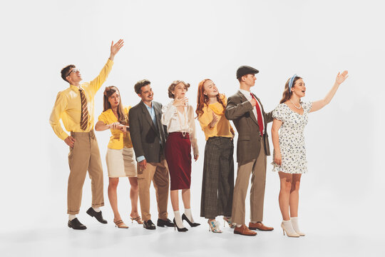 Group of young stylish people standing in a line, talking, expressing ideas isolated over white studio background