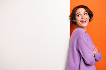 Photo of minded clever person folded hands look empty space brainstorming isolated on orange color background