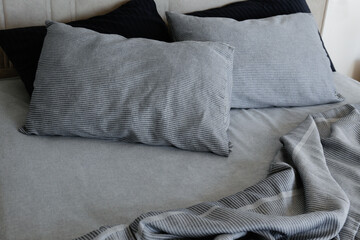 Room with an empty king sized bed with headboard, perfectly clean and ironed sheets, puffy pillows...
