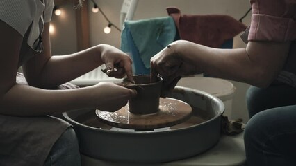 pottery professional teaches a girl how to make a vase, pottery training on a potter's wheel, hobby, master class