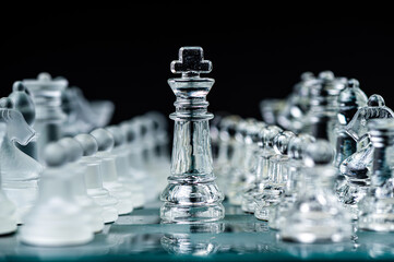 Transparent glass chess pieces on dark background. Leadership and  strategy concept, selective focus