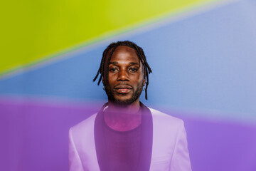 artistic portrait with gel lights. Handsome man posing on colored backgrounds. Artist singer...