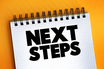 Next Steps text on notepad, concept background.