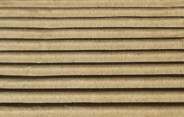 Abstract paper background. Texture with horizontal lines of light and shadow on the surface of corrugated cardboard.