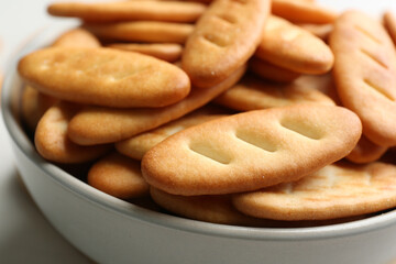 Delicious crispy crackers in bowl, closeup view