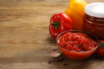 Delicious lecho, fresh vegetables and peppercorns on wooden table. Space for text