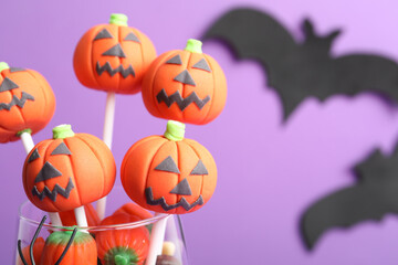 Delicious Halloween themed cake pops on violet background, closeup. Space for text