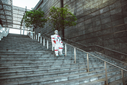 spaceman in a futuristic station. Man with space suit walking in an urban area