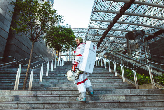 spaceman in a futuristic station. Man with space suit walking in an urban area