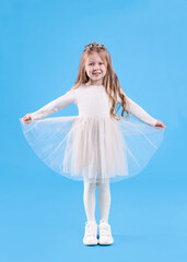 Naklejka premium Cute girl in beautiful dress with diadem on light blue background. Little princess