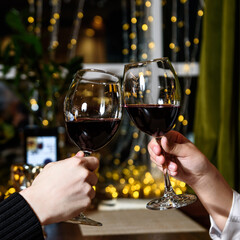 two glasses of red wine in hands