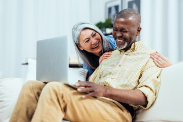cinematic image of an happy multiethnic senior couple. Indoors Lifestyle moments at home. Concept...