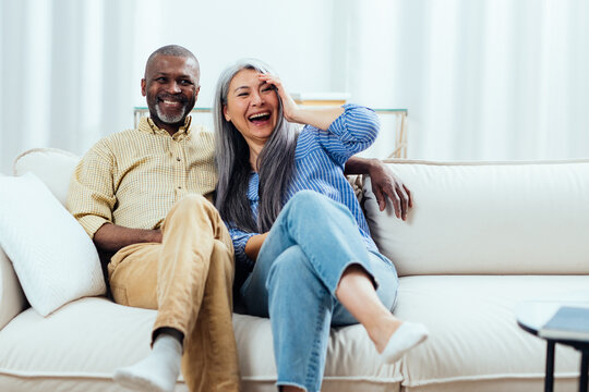 cinematic image of an happy multiethnic senior couple. Indoors Lifestyle moments at home. Concept about seniority and relationships