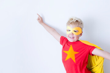 Caucasian boy in superhero costume over white background 