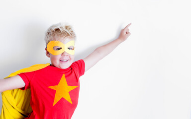 Caucasian boy in superhero costume over white background 