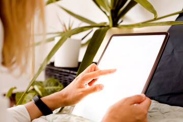 woman hand holding a tablet with white screen at home
