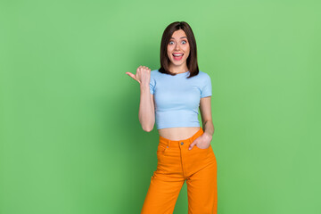 Photo of young attractive gorgeous nice woman unbelievable sale pointing empty space isolated on green color background