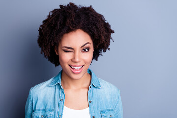 Photo of adorable cheerful lady beaming smile eye wink empty space isolated on grey color background