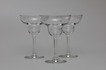 Transparent glasses for cocktails on a white background. Glasses for tequila, margarita, pina colada and other cocktails. Transparent cocktail glasses for bar