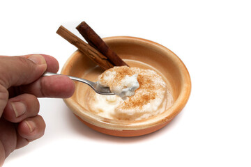 Delicious rice pudding with cinnamon isolated on white. Rice pudding is a typical dessert of the gastronomy of many countries made by slowly cooking rice with milk and sugar.