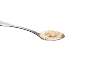 A spoonful of delicious rice pudding with cinnamon, isolated on white background. Rice pudding is a typical dessert in the gastronomy of many countries, made by slowly cooking rice pudding and sugar.