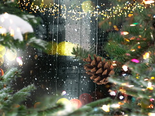 night Christmas tree view on street night city  bokeh   light , rain drops on glass, garland illumination with cone snow flakes town holiday scene