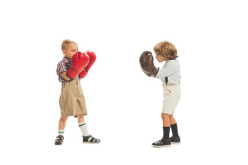 Funny kids in huge boxing gloves boxing together isolated on white studio background. Retro vintage style concept. Friendship, hobbies, art, sport