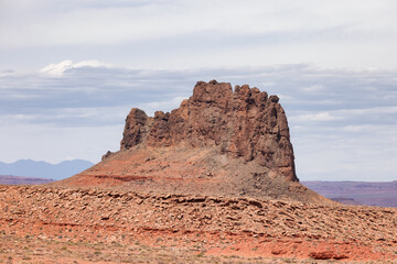 Fototapeta premium Red Rock Mountain Landscape during sunny and cloudy day. Alhambra Rock near Mexican Hat, Utah, United States. American Nature Background