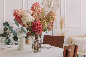 A beautiful bouquet of hydrangeas on the table in a modern cozy living room. Copy space. 