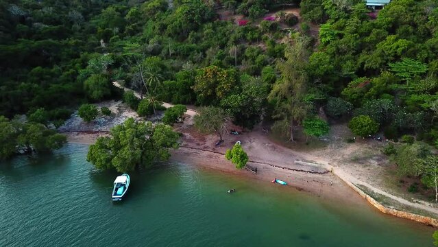Dock Boat At Kilifi Bay Reveals Dense Forest In Tropical Mountains In Kenya Coast, Africa. Aerial Drone Shot