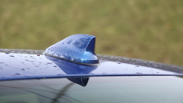 FM AM GPS radio antenna in the form of a shark fin on the roof of a blue car