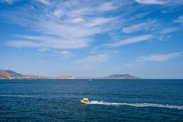 Small pleasure boat in sea. Beautiful summer nature. Black sea and blue sky. Vacation.