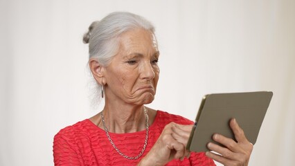 Portrait of mature elderly woman posing holding phone video chat isolated on solid white background.