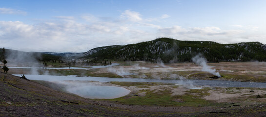 Hot spring Geyser with colorful water in American Landscape. Cloudy Sky Art Render. Yellowstone National Park, Wyoming, United States. Nature Background Panorama