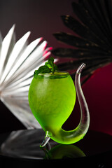 green cocktail on black background