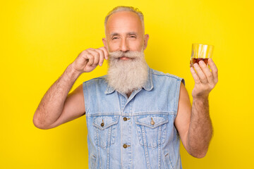 Photo of cute attractive man pensioner dressed denim vest enjoying strong alcohol drink isolated...
