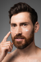 Fototapeta premium close up of bearded man with cream on face smiling isolated on grey.