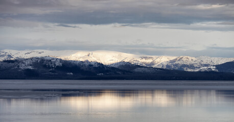 View of a frozen Yellowstone Lake with snow covered mountains in American Landscape. Yellowstone National Park. United States. Nature Background.