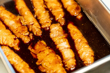 濃厚な醤油ダレに鶏皮串を漬け込む