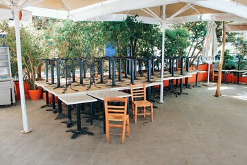 Tables and chairs stacked outside closed cafe-restaurant during the Coronavirus lockdown - Athens, Greece, May 6 2020.