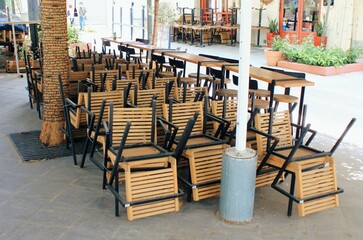 Tables and chairs stacked outside closed cafe-restaurant during the Coronavirus lockdown - Athens, Greece, May 6 2020.