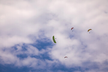 Paratroopers in the blue sky. Beautiful clouds and blue sky. Colorful parachutes. Extreme sport.