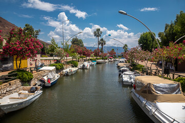 Beautiful river with trees on the shore. Small resort town. Beautiful canal with boats. Sunny summer day. Ancient European architecture.