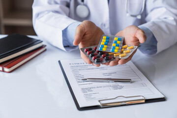 doctor or pharmacist advises patients about pills. The doctor prescribes medication sitting at a...