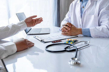 Doctor working in the office and listening to the patient, he is explaining him symptoms, healtcare and assistance concept