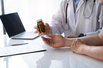 doctor or pharmacist advises patients about pills. The doctor prescribes medication sitting at a table in the clinic office. to find the best course of treatment. follow-up treatment