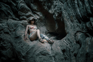 Beautiful girl on the rocks in the canyon. Dry bed of a former river. Girl in swimsuit. Small beautiful canyon.