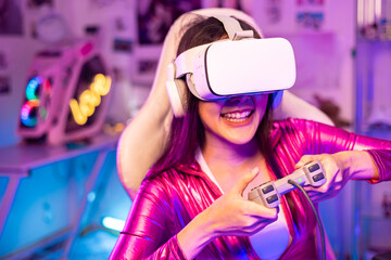 Young asian woman is using virtual reality headset. Neon light studio portrait. Concept of virtual reality, simulation, gaming and future technology.Asian woman play game in living room.